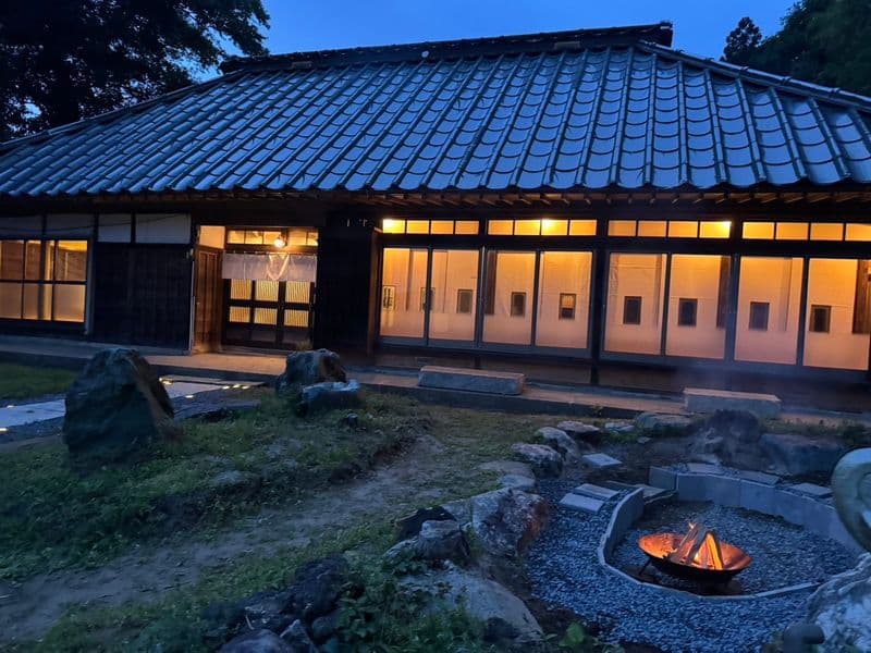 夕暮れの母屋と、庭に据えた焚き火台