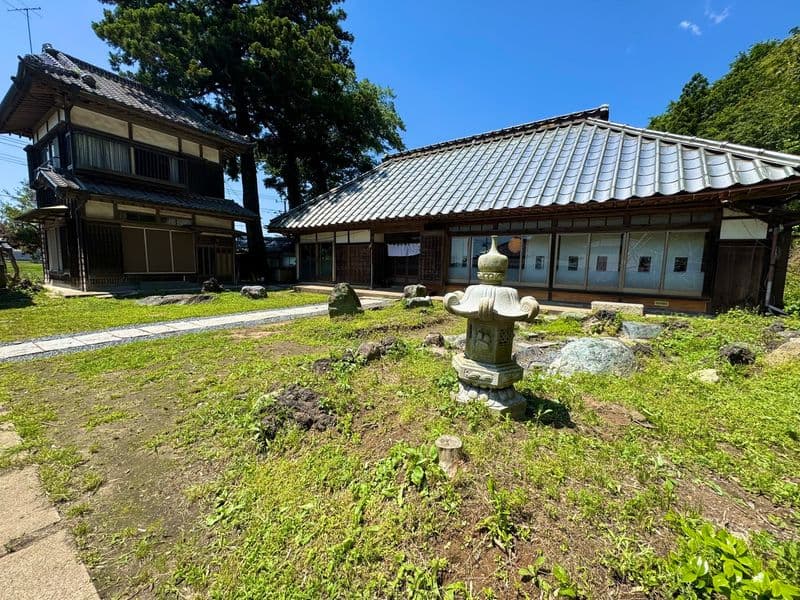 晴れた日の敷地。母屋と石灯籠、隣接する建物